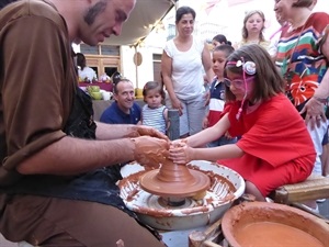 Una niña practicando el moldeado de barro en el Mercado Medieval