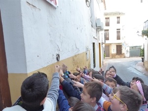 Los alumnos de 2º A del CP Sant Rafel buscando "anelles" en la fachada de las casas de La Nucía