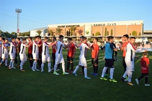 Los dos equipos saludándose antes del inicio del partido